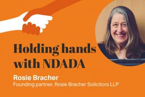 Holding hands with NDADA logo with Rosie Bracher