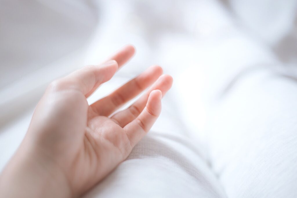 persons hand on white textile - relaxation exercise